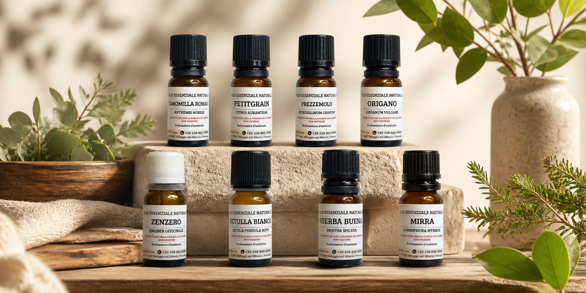 Boccette di oli essenziali circondate da elementi botanici